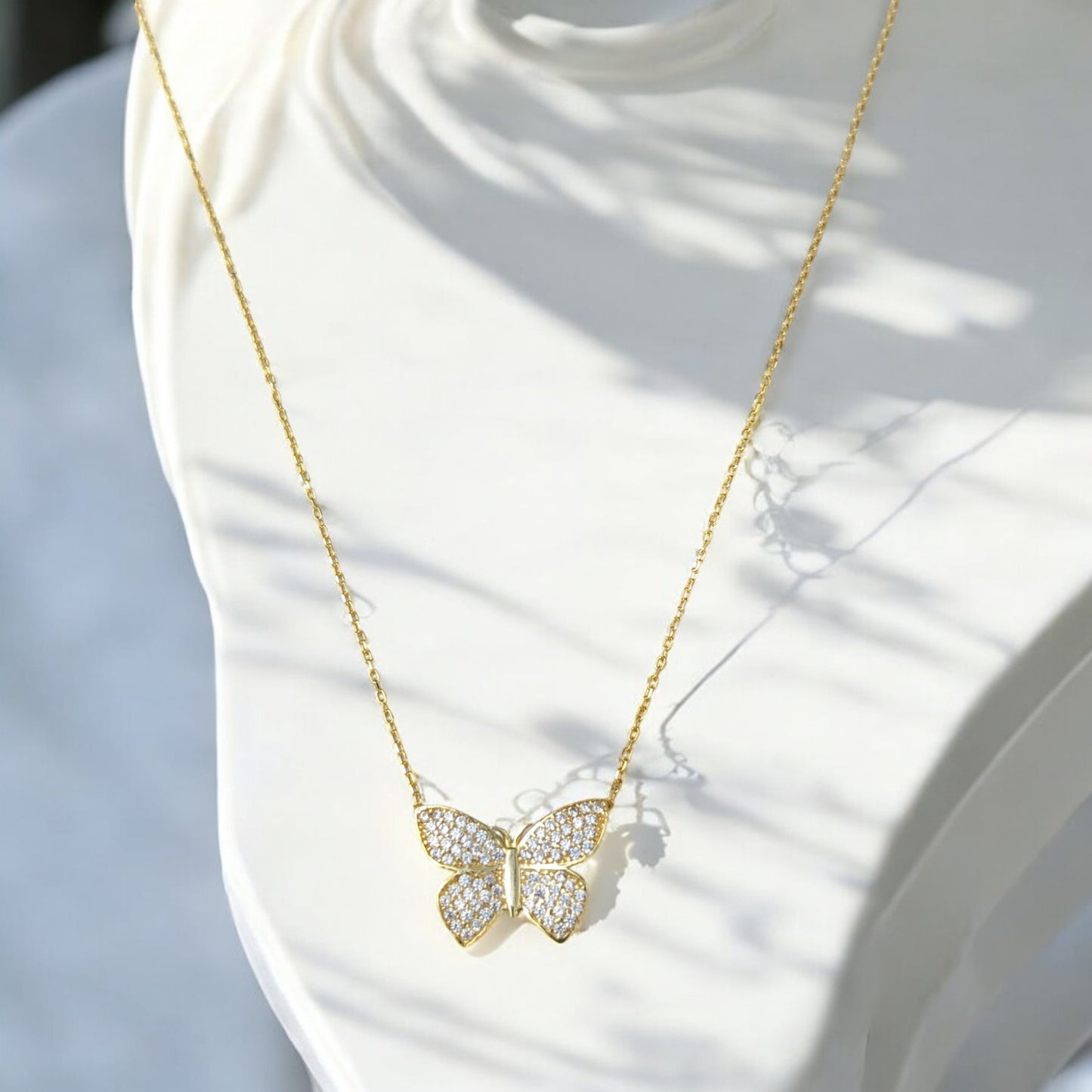18K yellow gold butterfly necklace with clear stones.
