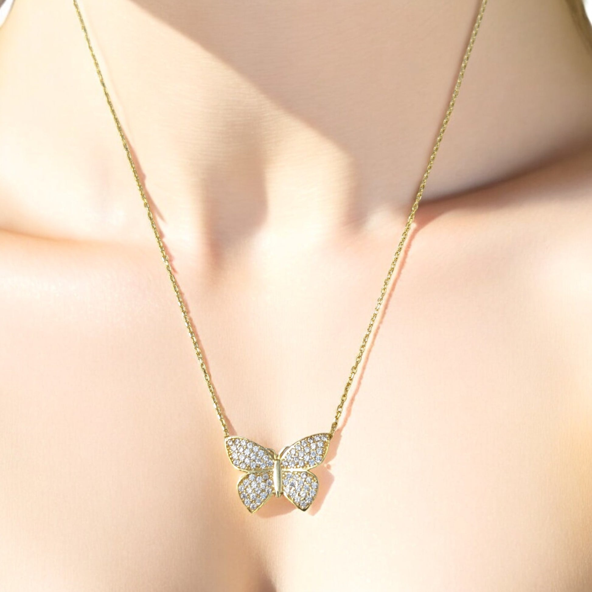 18K yellow gold butterfly necklace with clear stones.