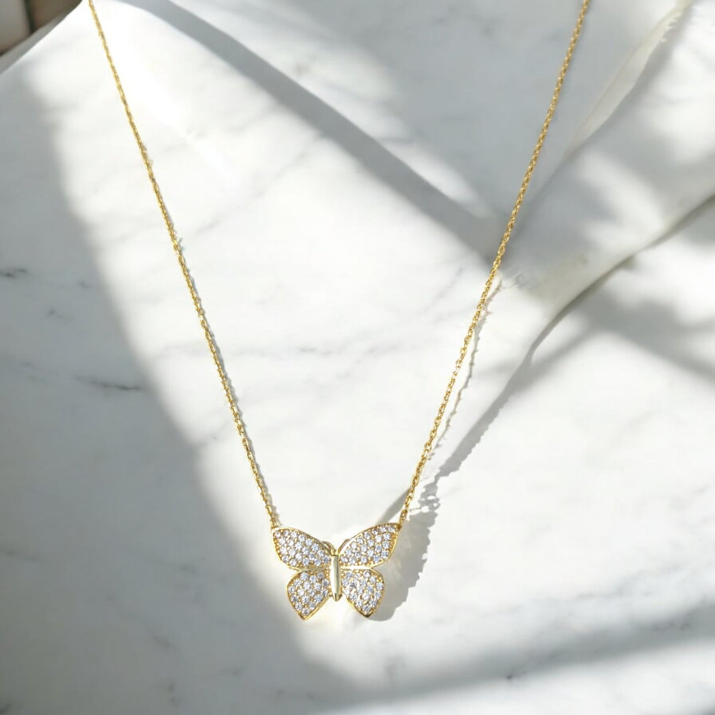 18K yellow gold butterfly necklace with clear stones.