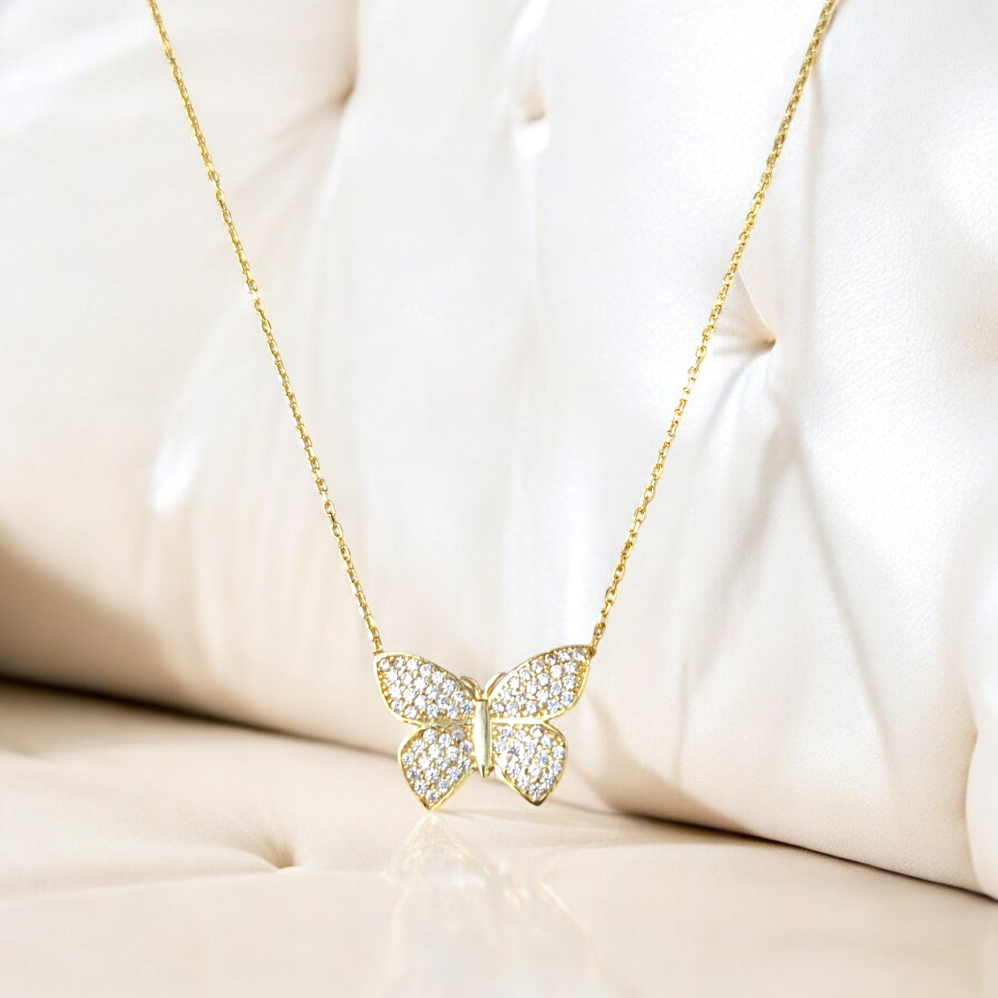 18K yellow gold butterfly necklace with clear stones.