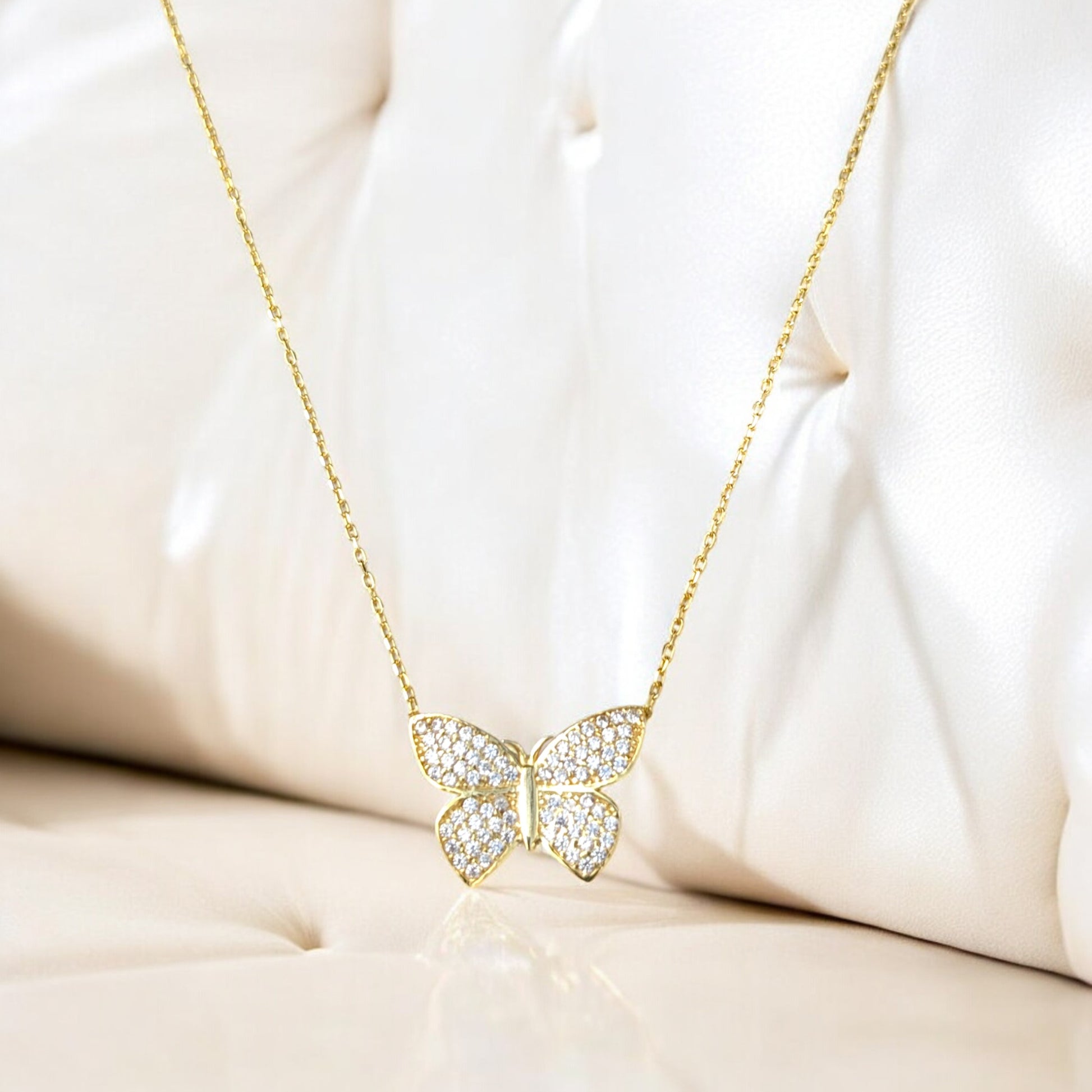 18K yellow gold butterfly necklace with clear stones.