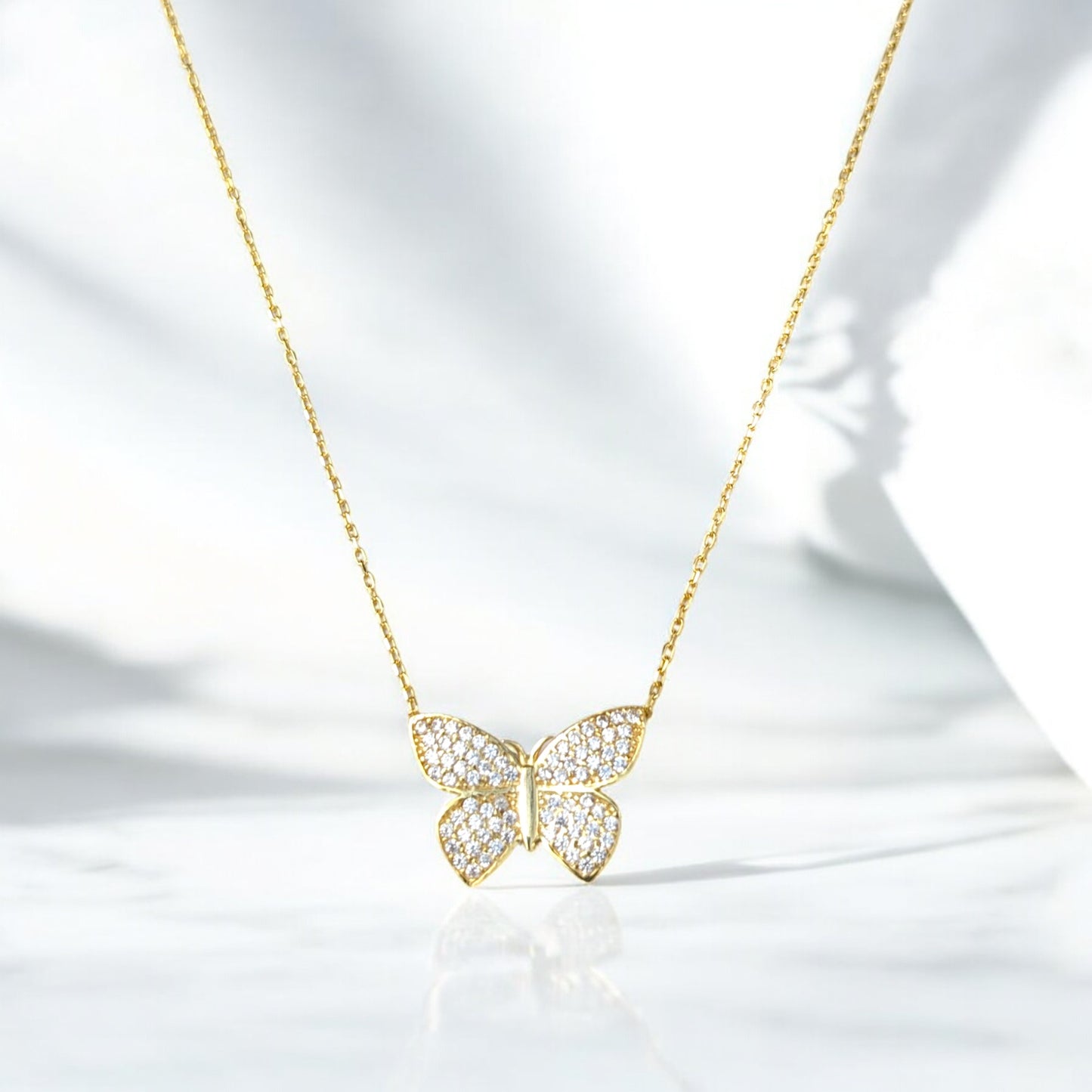 18K yellow gold butterfly necklace with clear stones.