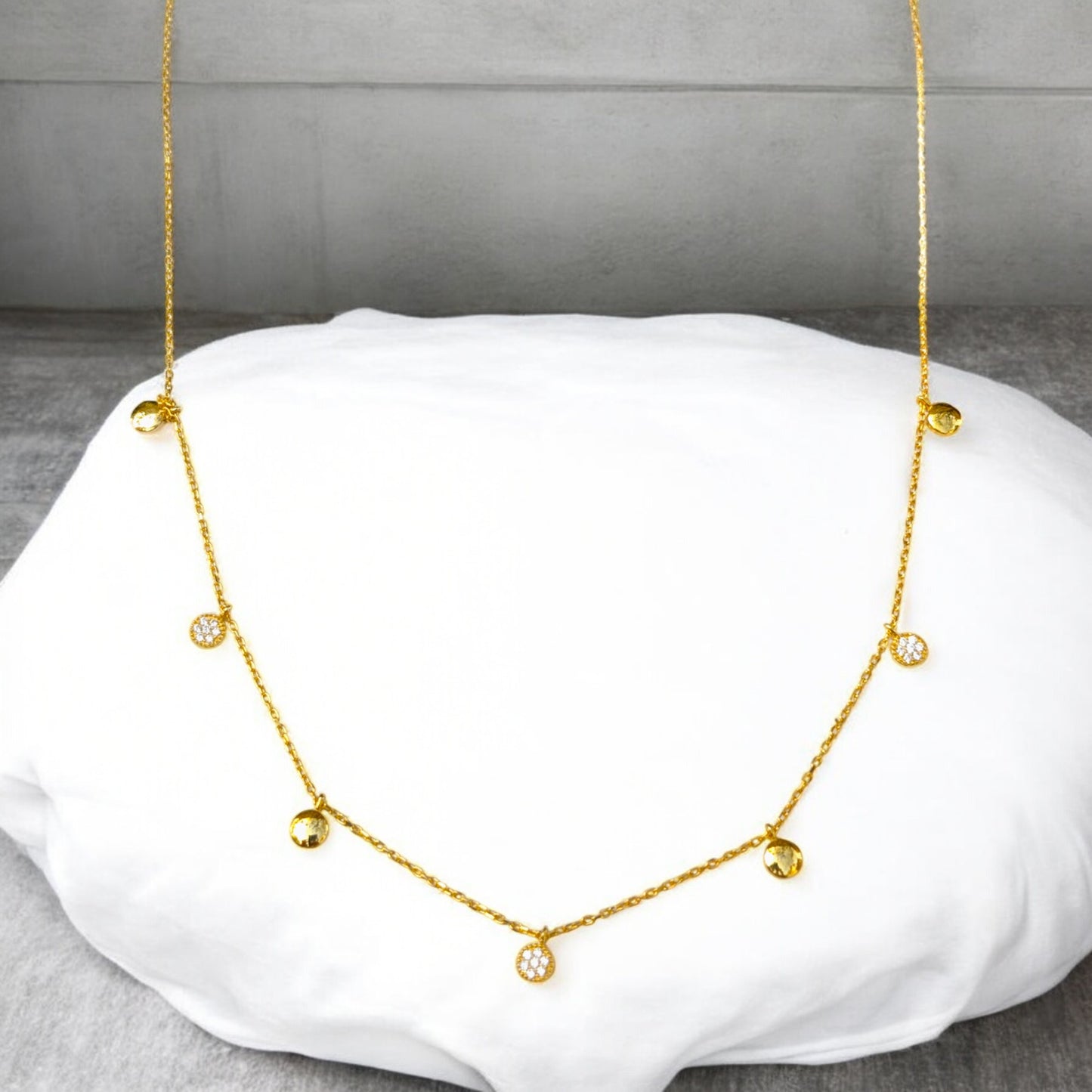 Delicate gold collar necklace with gold discs and clear stone charms