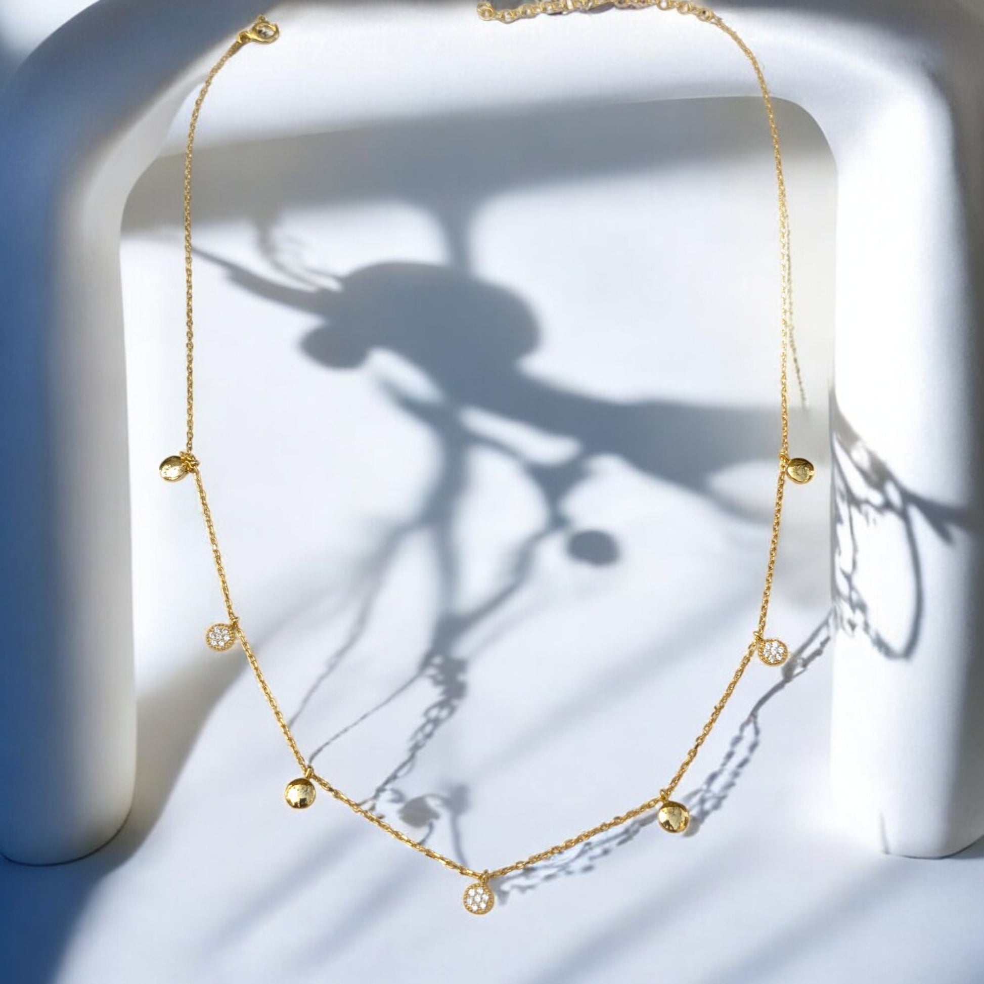 Delicate gold collar necklace with gold discs and clear stone charms