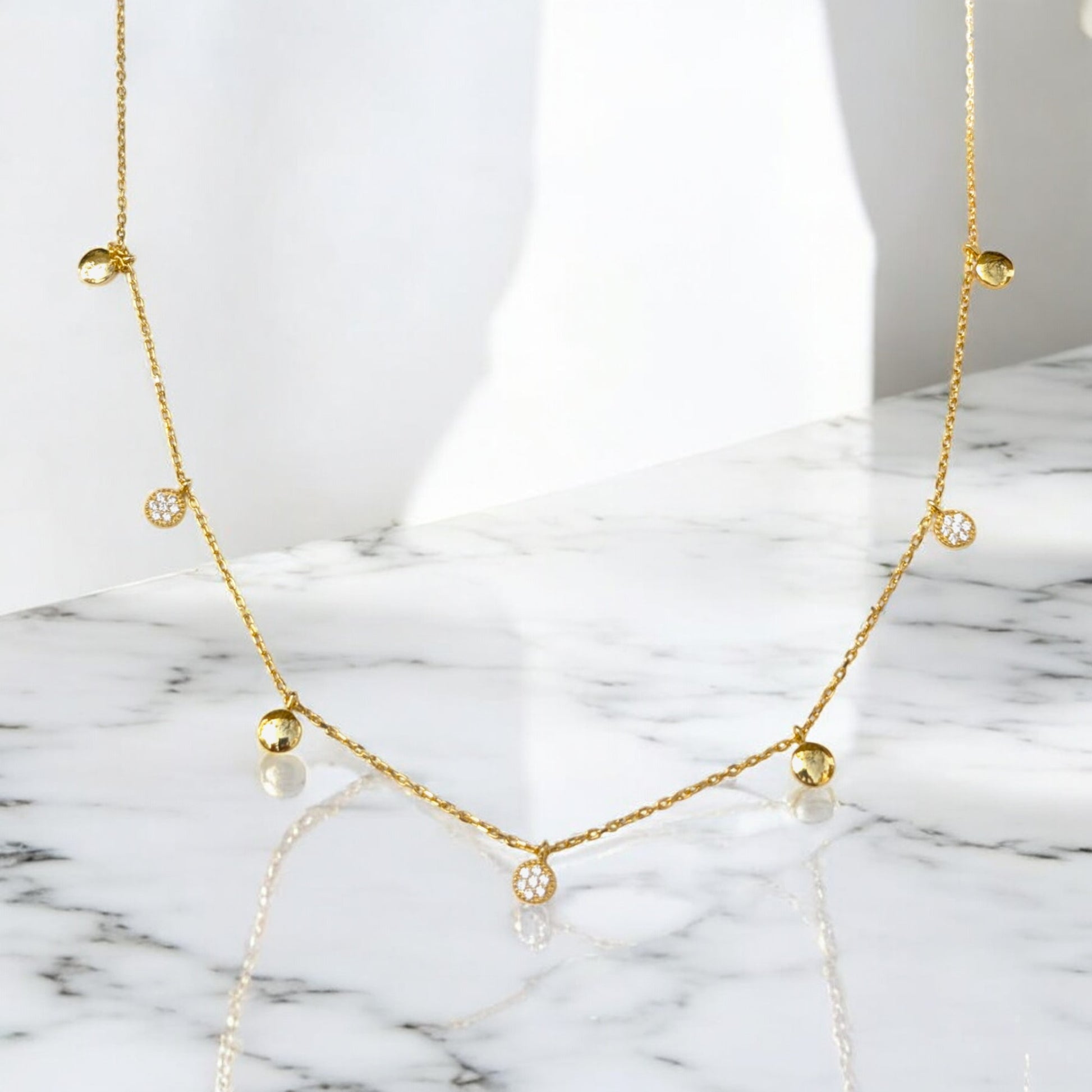 Delicate gold collar necklace with gold discs and clear stone charms