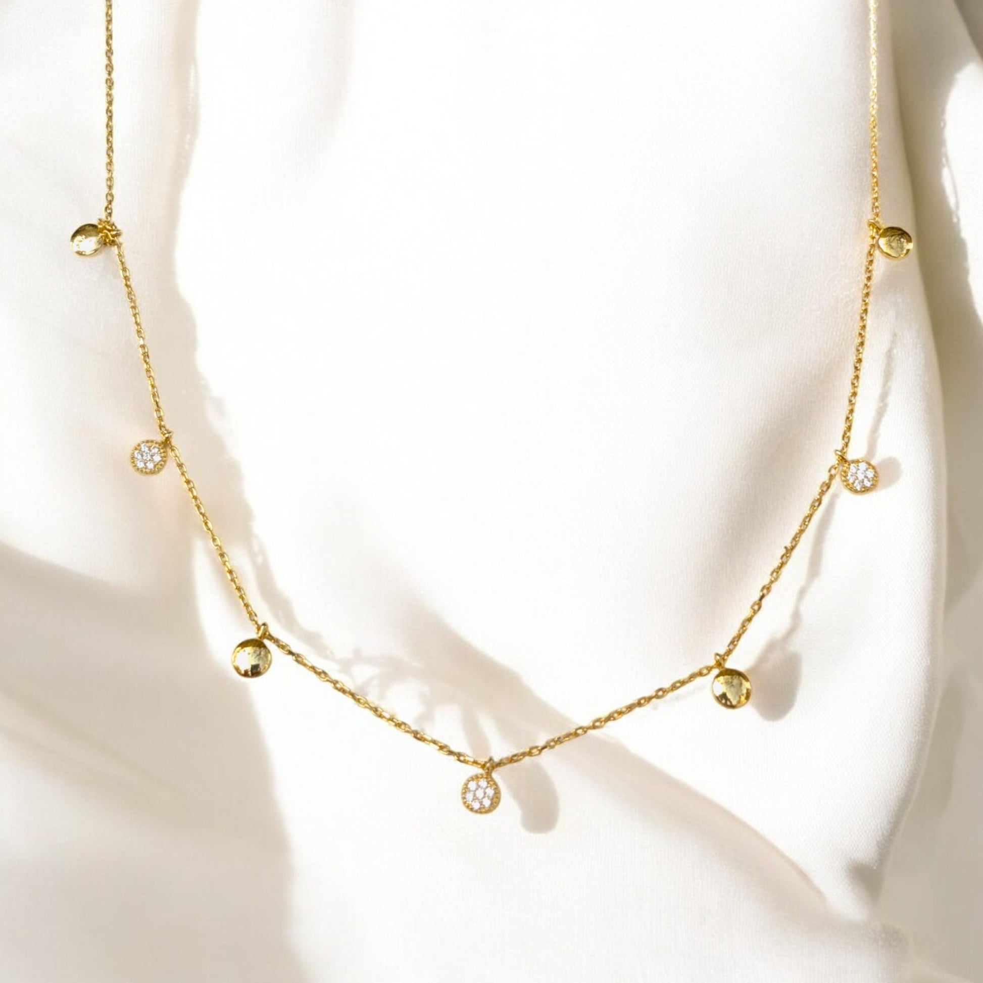 Delicate gold collar necklace with gold discs and clear stone charms