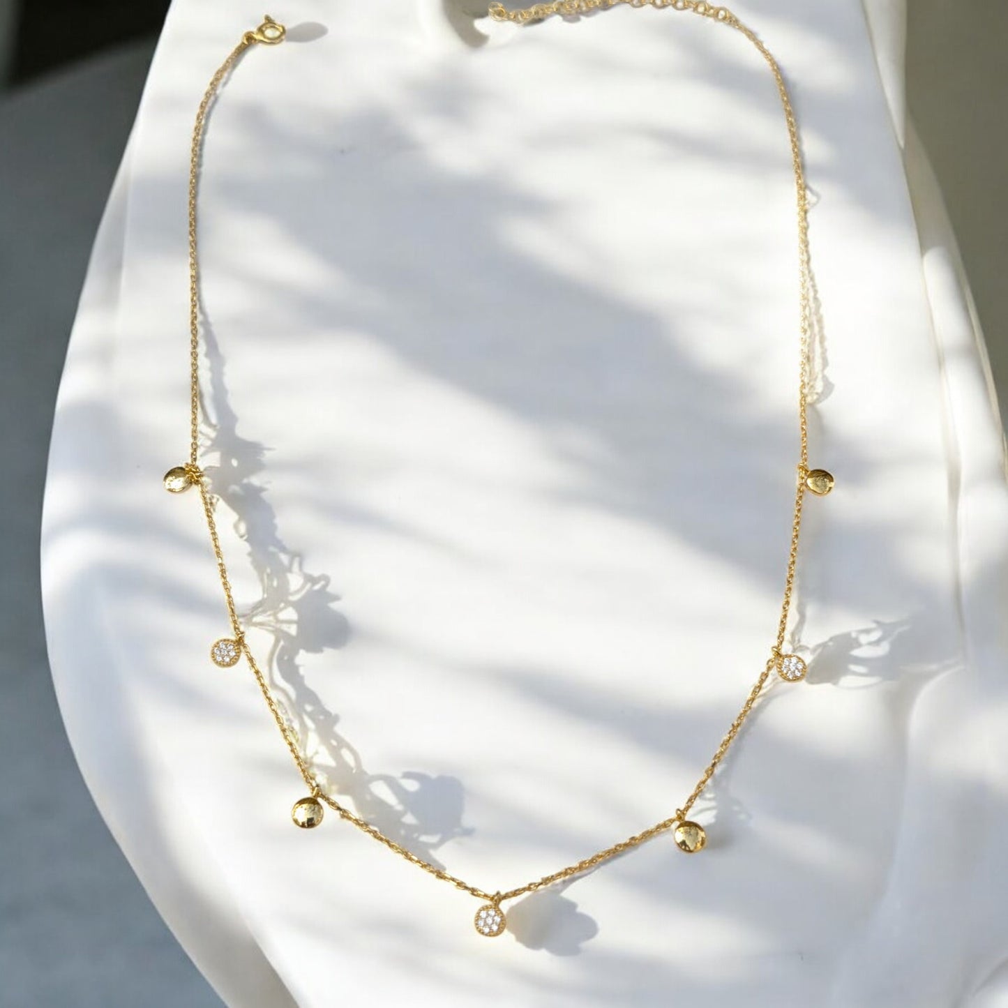Delicate gold collar necklace with gold discs and clear stone charms
