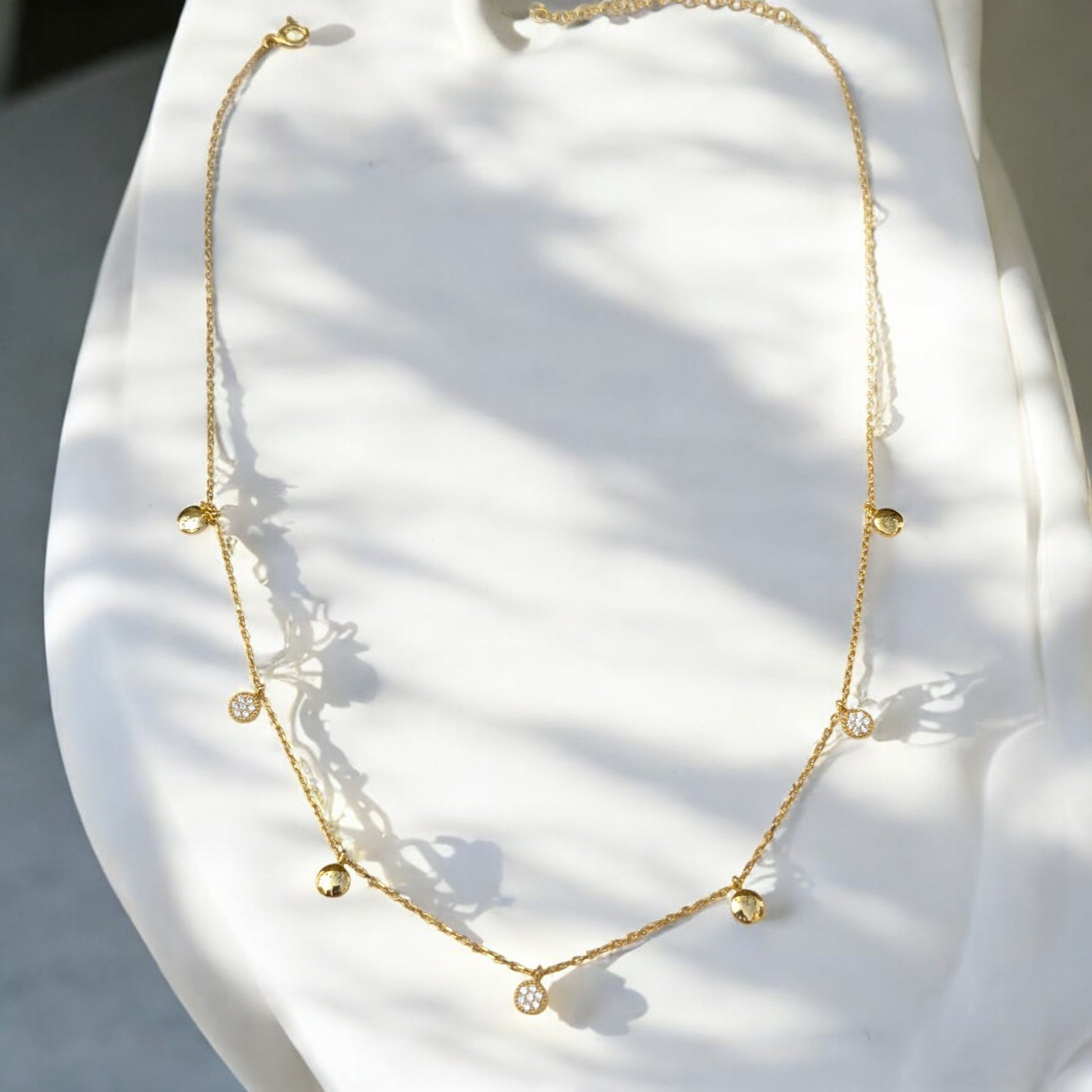 Delicate gold collar necklace with gold discs and clear stone charms