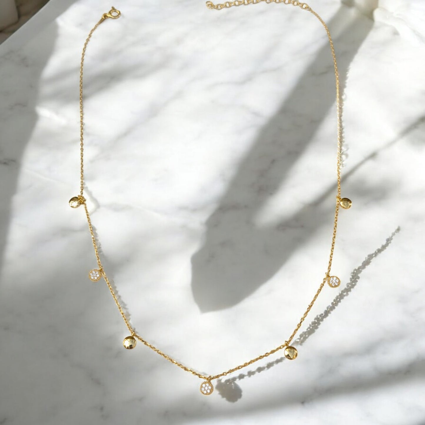 Delicate gold collar necklace with gold discs and clear stone charms