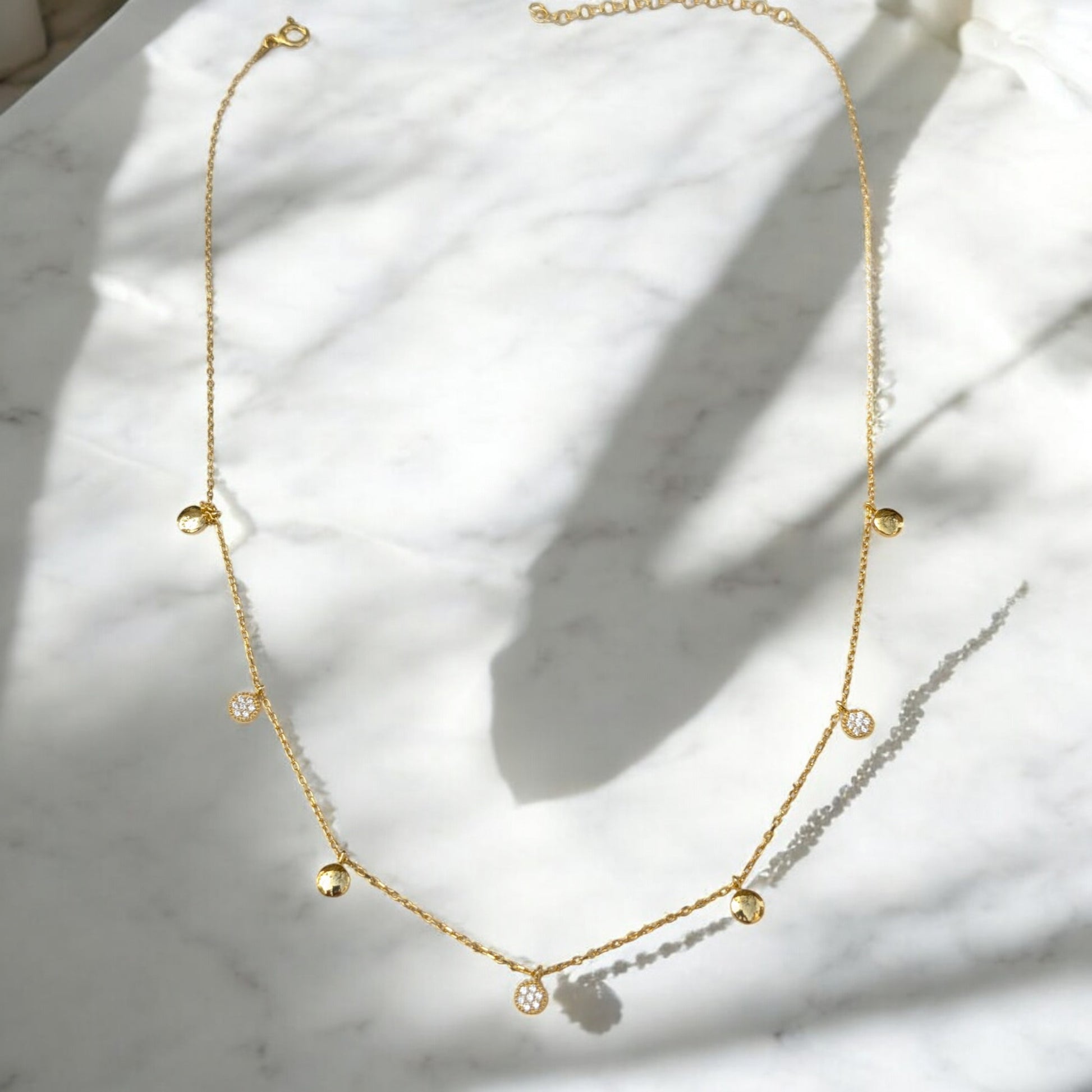 Delicate gold collar necklace with gold discs and clear stone charms