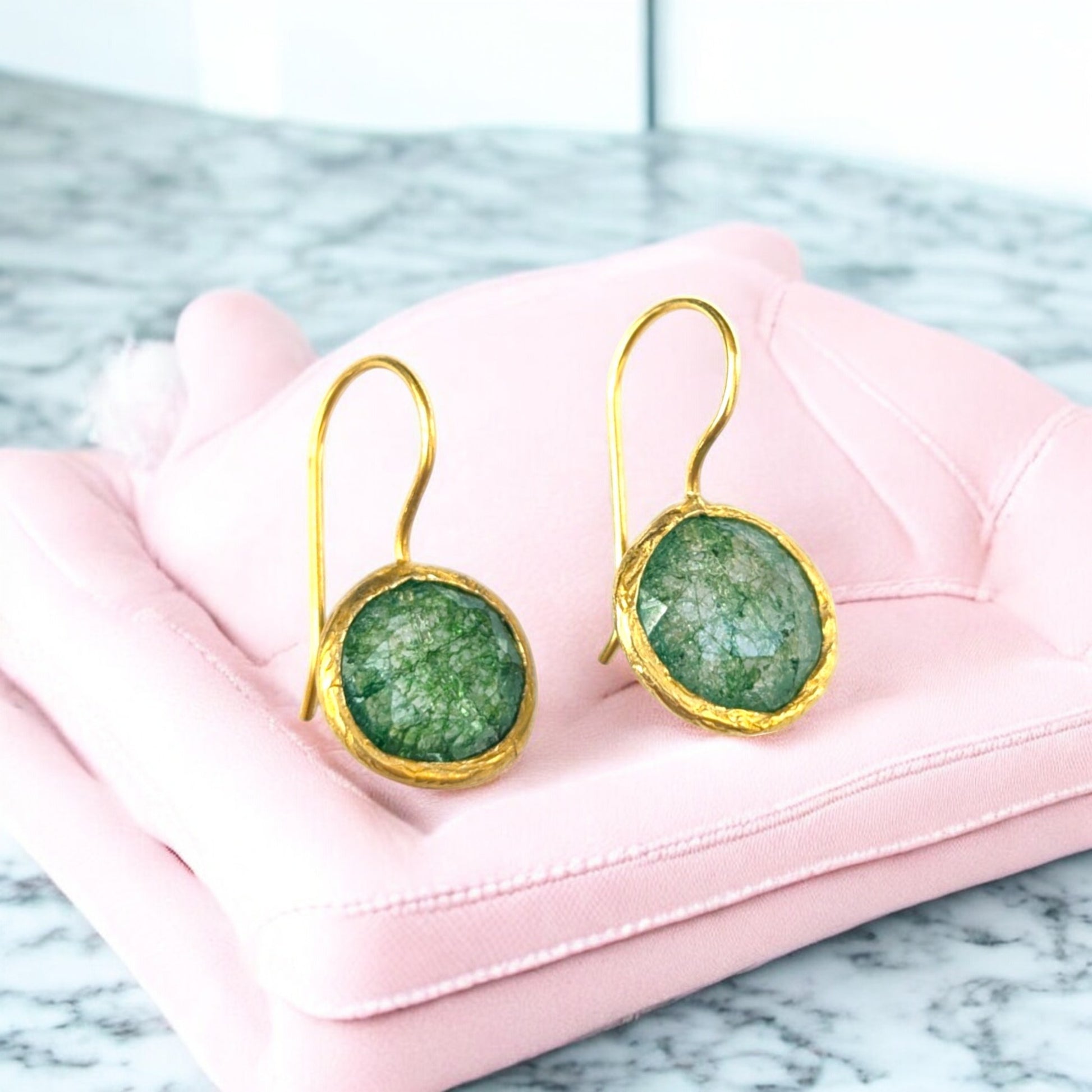 Green fusion stone drop earrings with gold bezels and hook ear wires.