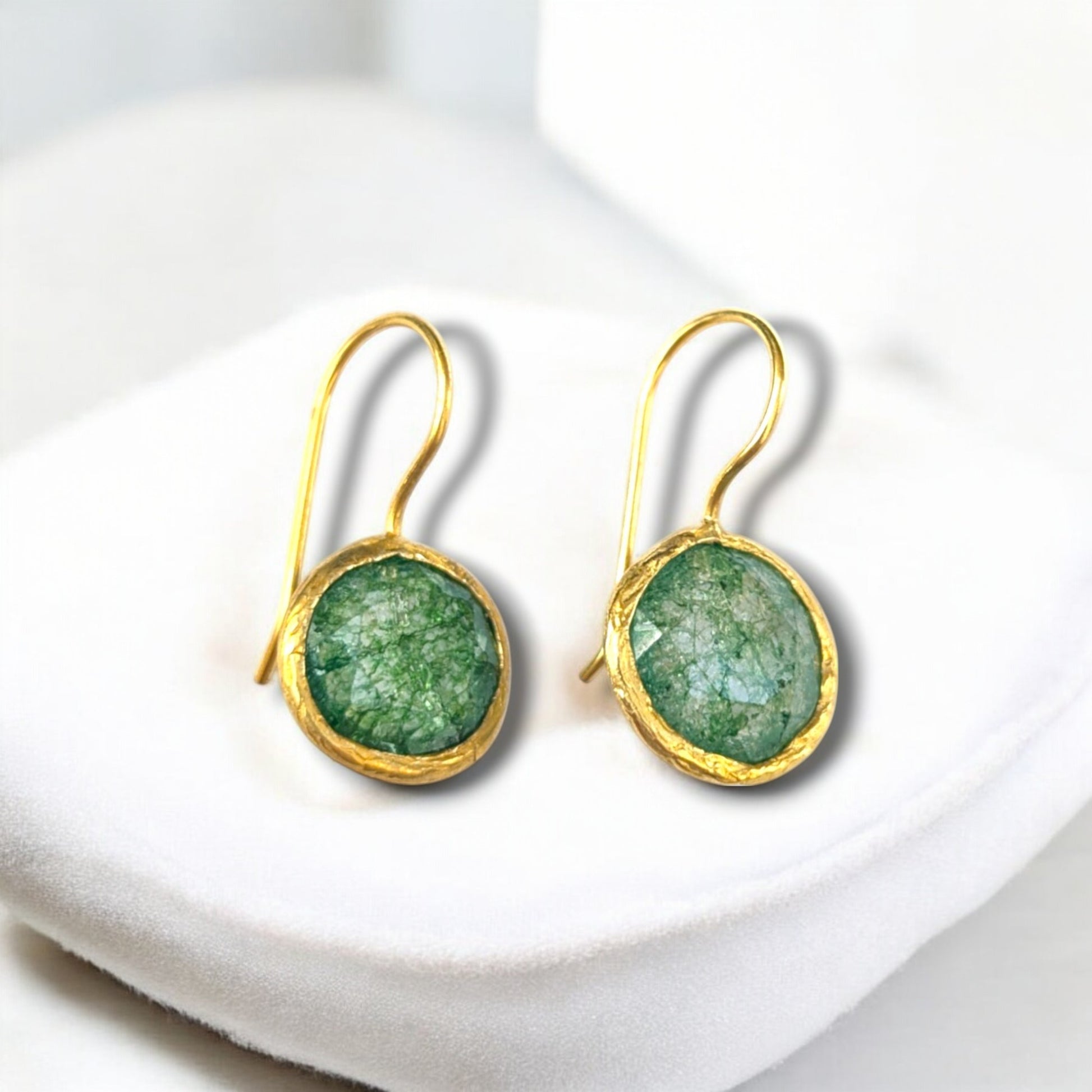 Green fusion stone drop earrings with gold bezels and hook ear wires.