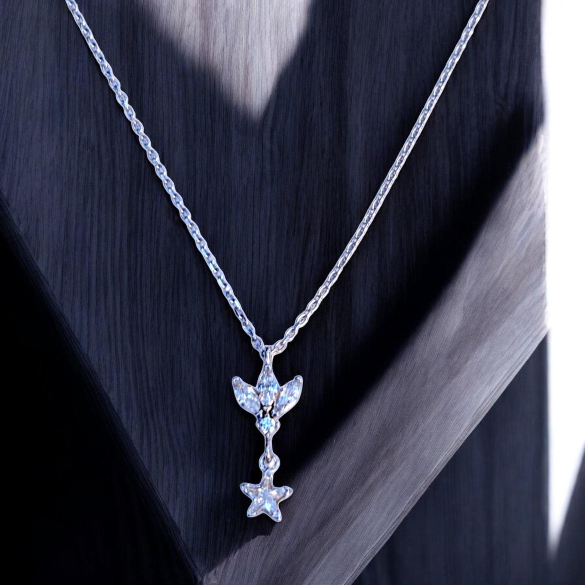 Silver chain necklace with floral/leaf pendant and star charm
