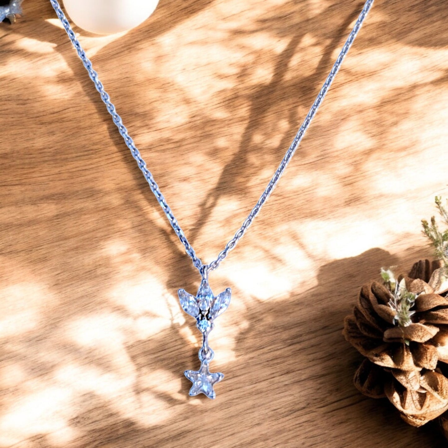 Silver chain necklace with floral/leaf pendant and star charm