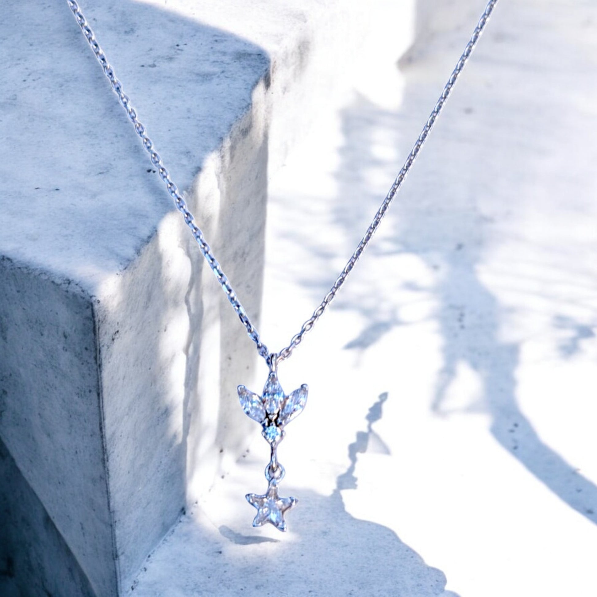 Silver chain necklace with floral/leaf pendant and star charm