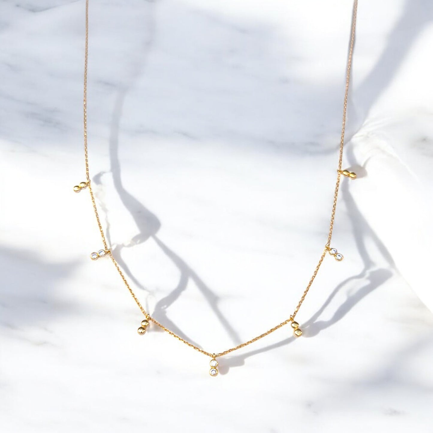 Delicate gold necklace with bezel-set CZ accents