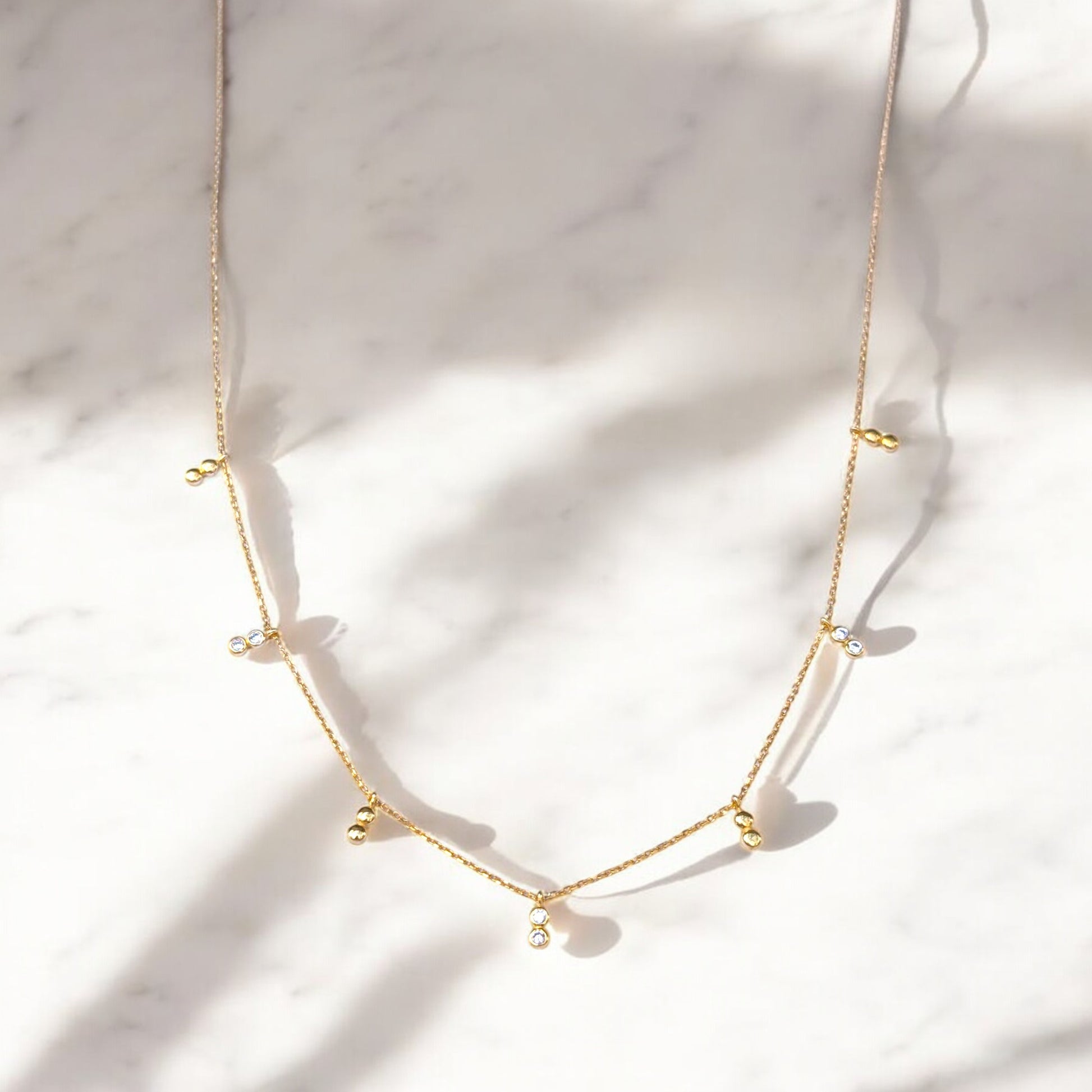 Delicate gold necklace with bezel-set CZ accents