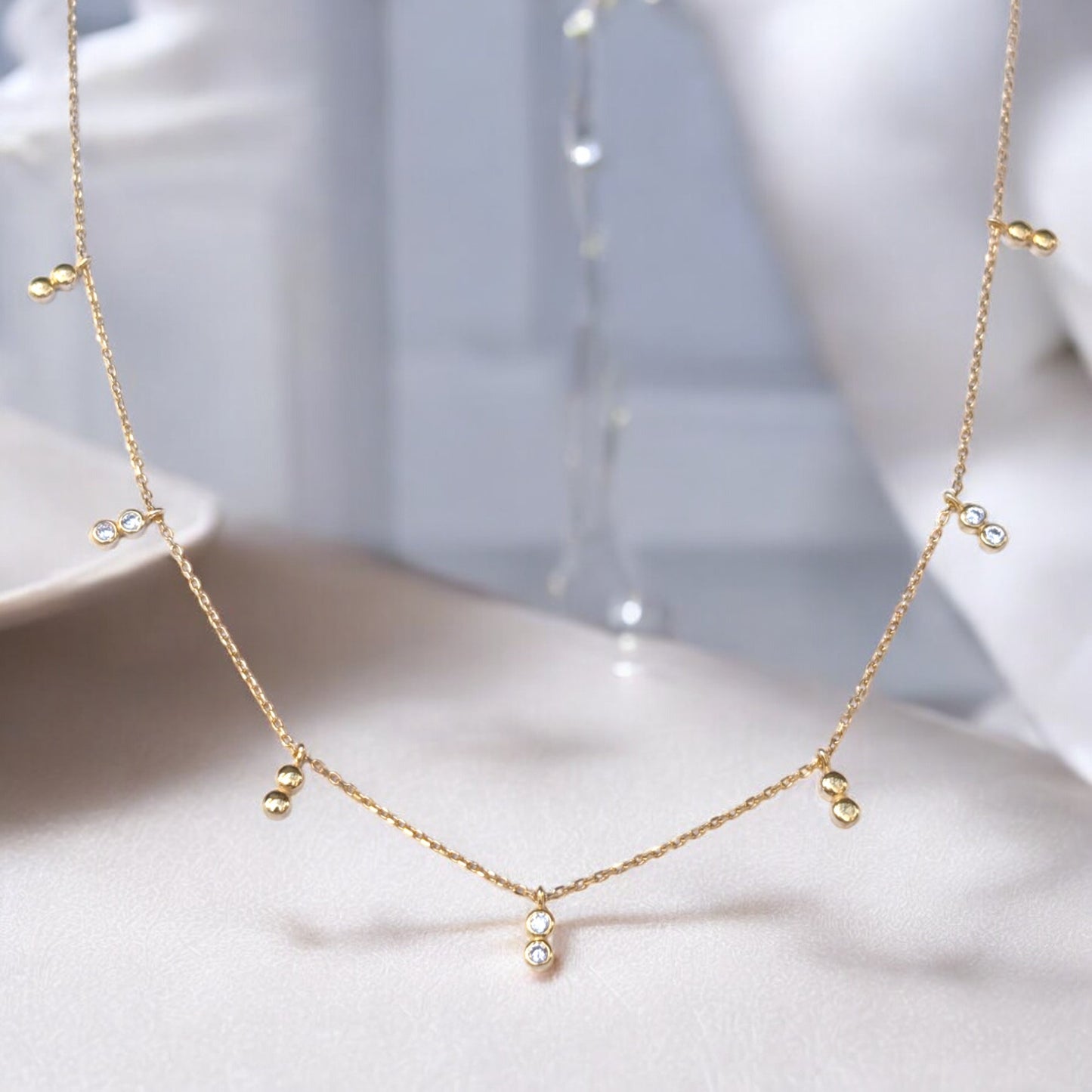 Delicate gold necklace with bezel-set CZ accents