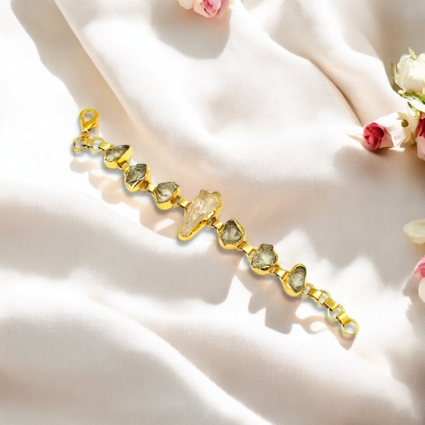 Raw green amethyst and clear quartz bracelet with gold plating on white background
